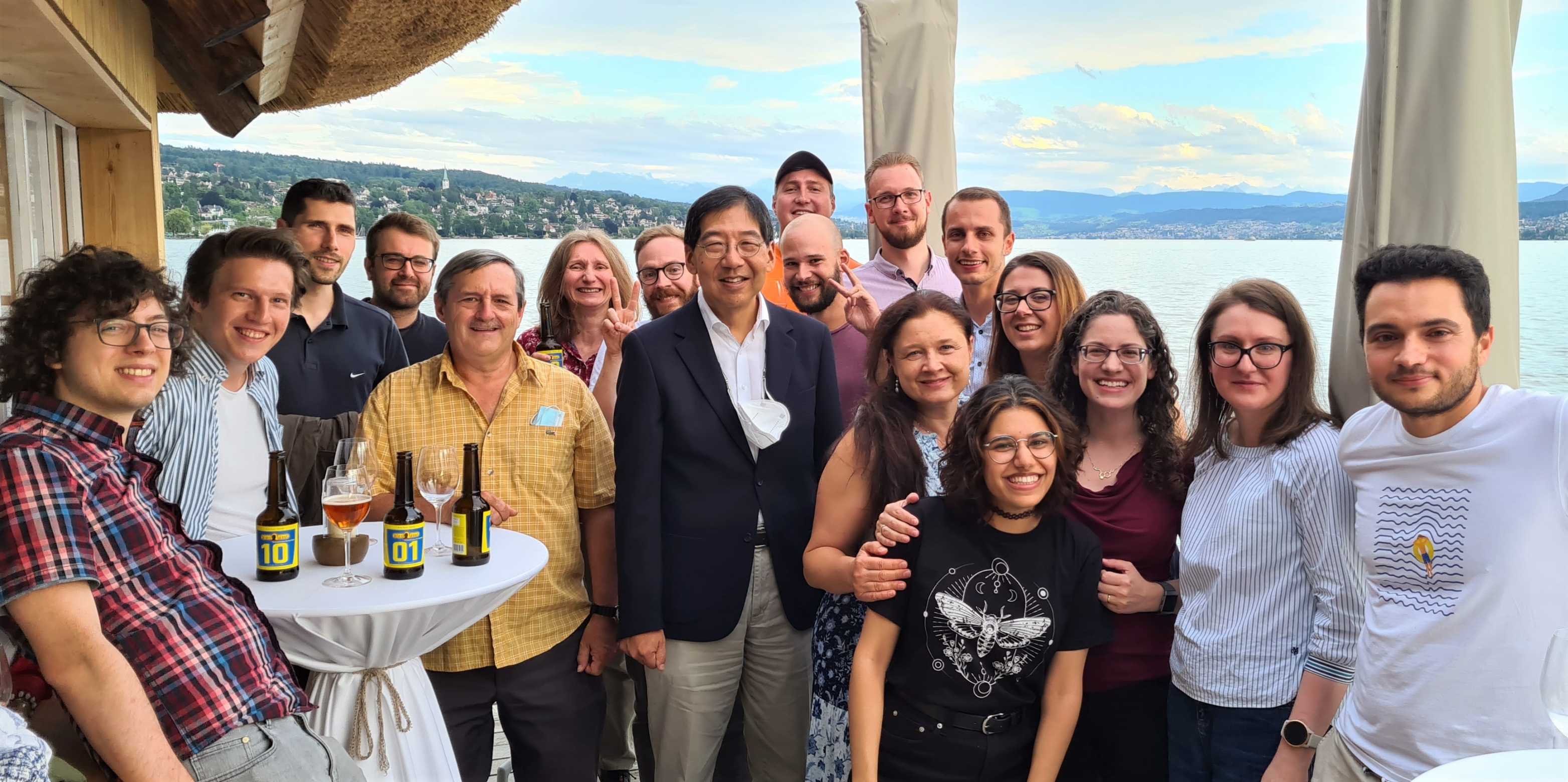 Prof. Chen surrounded by group members, at a restaurant terrasse at the Lake of Zurich on a summer evening in 2021